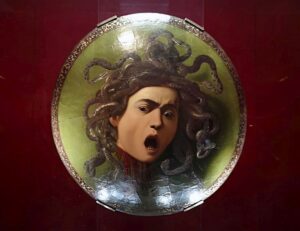 l'immagine mostra la testa del mostro Medusa, con la testa piena di serpenti. Immagine ritratta su di uno scudo